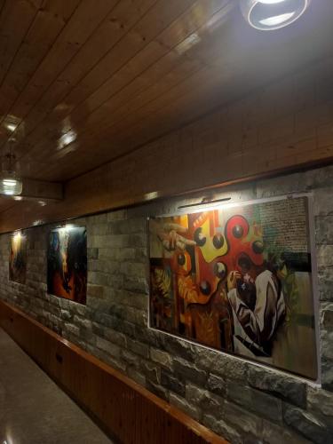 un muro con dipinti su un muro di mattoni di Foresta Living Kasol a Kasol