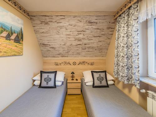 twee bedden in een kleine kamer met een raam bij WERONIKA Murzasichle in Murzasichle