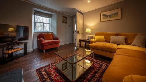 een woonkamer met een bank en een salontafel bij Dunvegan Castle Rose Valley Cottage in Dunvegan