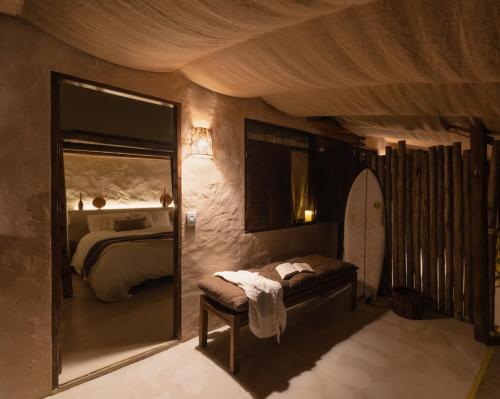 a bedroom with a mirror and a bed and a surfboard at Mōmento Itamambuca in Ubatuba