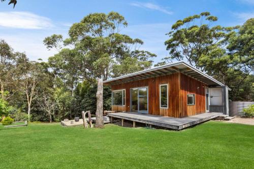 a small wooden house with a large yard at Flounder in Lake Tyers