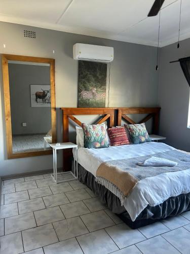 una camera da letto con un letto grande e uno specchio di Protea Guesthouse a Phalaborwa