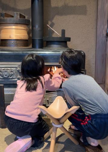 un uomo e una bambina che cucinano in un forno di うご八かやぶ㐂 a Narazaki