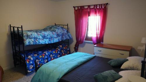 een slaapkamer met twee stapelbedden en een raam bij Casa Vacanza Bettega in Pianosinatico