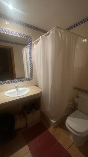 a bathroom with a sink and a toilet and a mirror at Casa Praia Verde V3 in Castro Marim