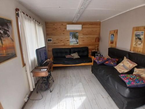 ein Wohnzimmer mit einem schwarzen Ledersofa und einem Schreibtisch in der Unterkunft TerraNostra in Mar de Cobo