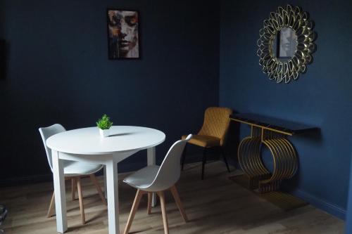 een eetkamer met een witte tafel en stoelen bij Résidence Saint Pôl in Nogent-le-Rotrou