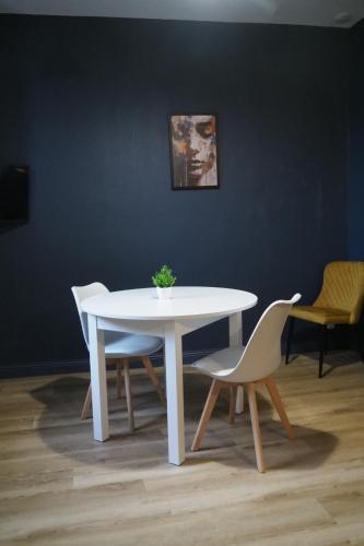 een witte tafel en stoelen in een kamer bij Résidence Saint Pôl in Nogent-le-Rotrou