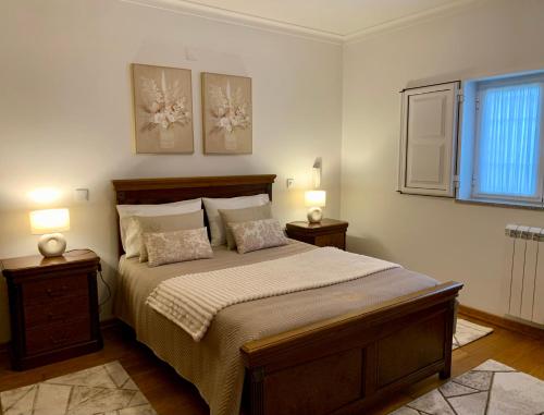 a bedroom with a bed with two lamps and a window at Casa Vista para a Serra in Casais do Livramento