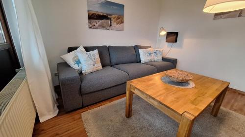 een woonkamer met een bank en een tafel bij PEMATRA Ferienwohnungen Ostseestrasse 2 in Travemünde