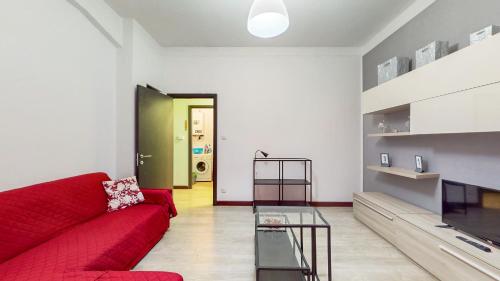 ein Wohnzimmer mit einer roten Couch und einer grünen Tür in der Unterkunft AltaVista in Acqui Terme