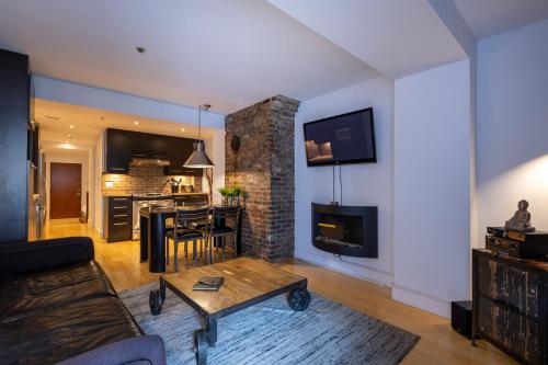 a living room with a couch and a fireplace at Les Immeubles Charlevoix - Le 1168 in Quebec City