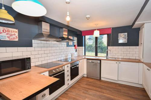 a large kitchen with white appliances and wooden floors at 3 Private Rooms in Shared Apartment with Kitchen in Leeds