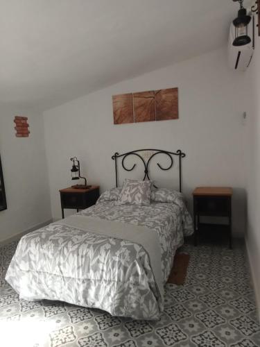 une chambre avec un lit et deux tables de nuit dans l'établissement Casa de los Abuelos, à Cardeña