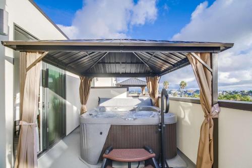 an outdoor kitchen with a table and a chair on a balcony at Park Blvd 302 - Newly Built - Spa - Central in San Diego