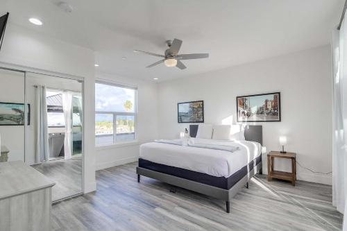 a white bedroom with a bed and a ceiling fan at Park Blvd 302 - Newly Built - Spa - Central in San Diego