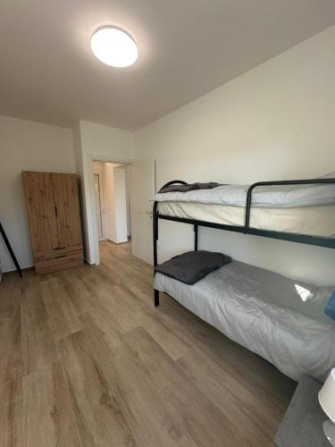 a room with two bunk beds and a wooden floor at Appartamenti Cataleya in Cuccurano