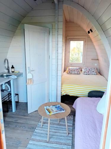 a room in a tiny house with a bed and a table at L'Escapade dans les Prés in Les Pégués