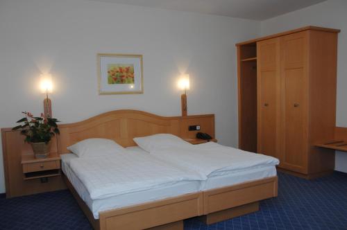 ein Bett in einem Schlafzimmer mit zwei eingeschalteten Lampen in der Unterkunft Hotel Zur Eich in Wermelskirchen