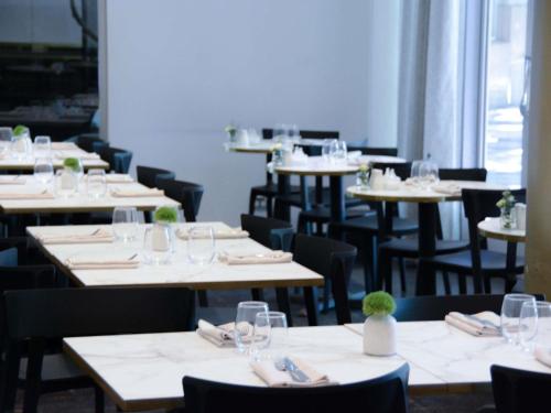 una fila de mesas y sillas en un restaurante en The Como Melbourne, en Melbourne