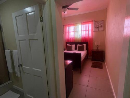 Habitación con dormitorio con cama y puerta en The Colosseum St Kitts, en Basseterre