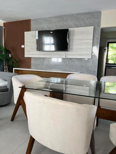 una sala da pranzo con un tavolo di vetro e sedie bianche di Villa Medrano 