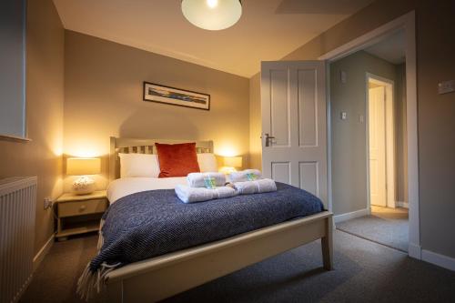 een slaapkamer met een bed met twee handdoeken erop bij Dunvegan Castle Laundry Cottage in Dunvegan