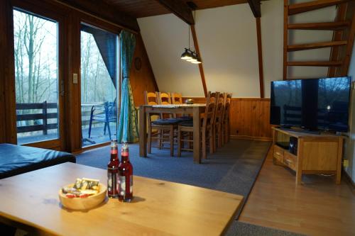 a living room with a table and a television at Twiste Retreat 126 in Bad Arolsen