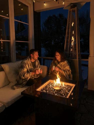 a man and woman sitting on a couch in front of a table with candles at Le 900 Tremblant Inn Café and Bistro in Mont-Tremblant