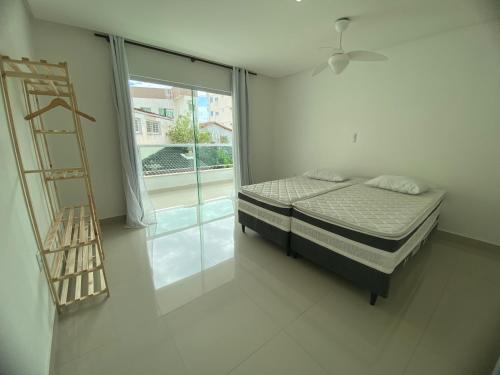 a bedroom with a bed and a ladder next to a window at Requinte e Conforto em Guarapari in Guarapari