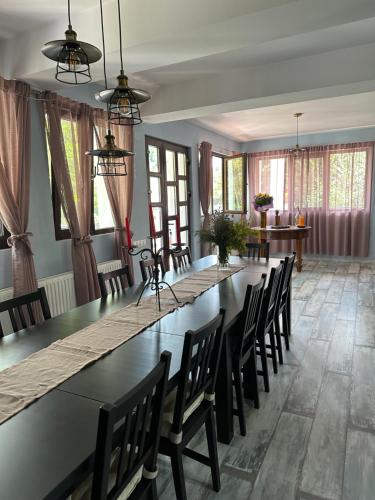 una grande sala da pranzo con un lungo tavolo e sedie di MURMUR Chalet a Valea Tîrsei