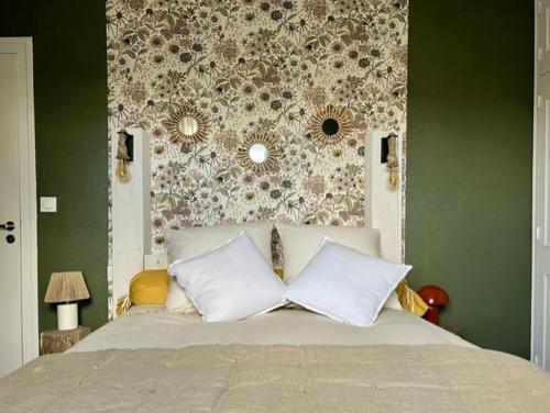 a bedroom with a bed with a floral wall at Le Chant Des Roseaux in Nantheuil