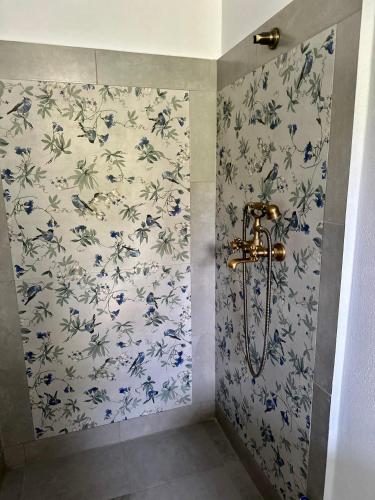 a bathroom with a shower with blue and white wallpaper at MURMUR Chalet in Valea Tîrsei