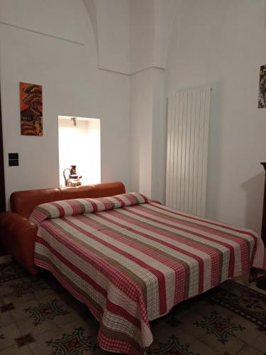a bedroom with a bed with a striped blanket at B&B Casa dolce casa in Cutrofiano