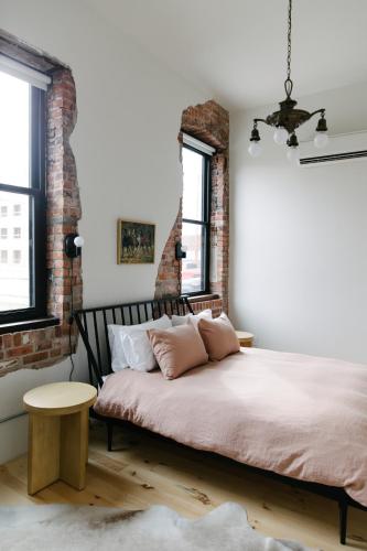 a bedroom with a bed and a brick wall at Hotel Royal in Toledo