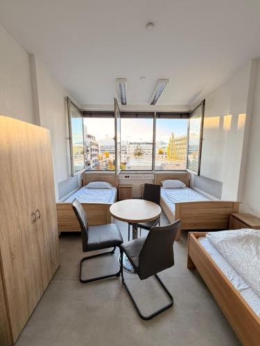 een kamer met twee bedden en een tafel en stoelen bij Haus an der Brücke in München