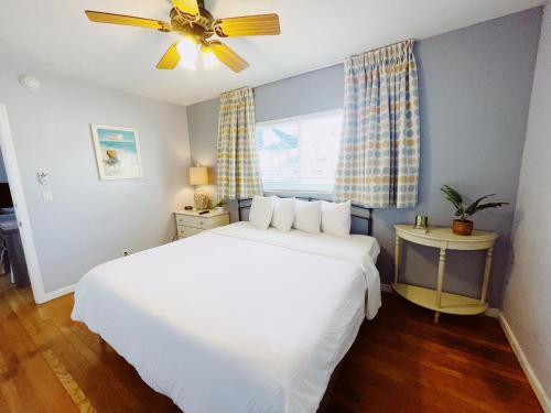 a bedroom with a white bed and a ceiling fan at Great Escape Apartments By Lowkl in Fort Lauderdale
