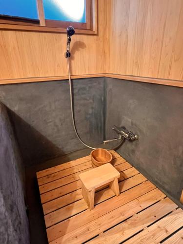 a bathroom with a shower with a wooden floor at うご八かやぶ㐂 in Narazaki