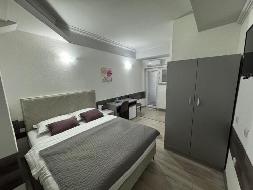 a bedroom with a large bed and a cabinet at Banja Luka Arcadia in Banja Luka