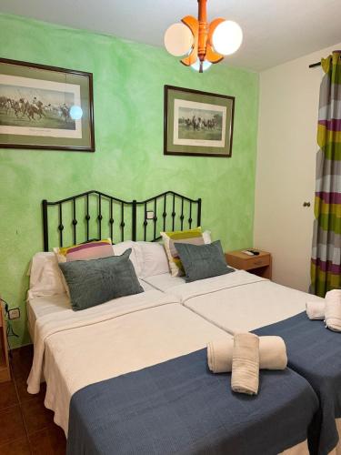 two beds in a bedroom with green walls at Bar Posada Bemi in Almorox