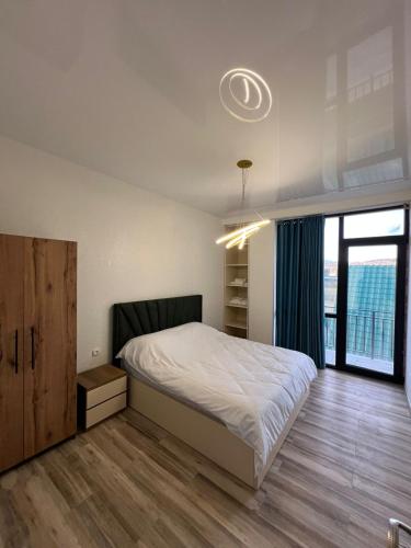 a bedroom with a bed and a large window at Marhaba Villa in Borjomi