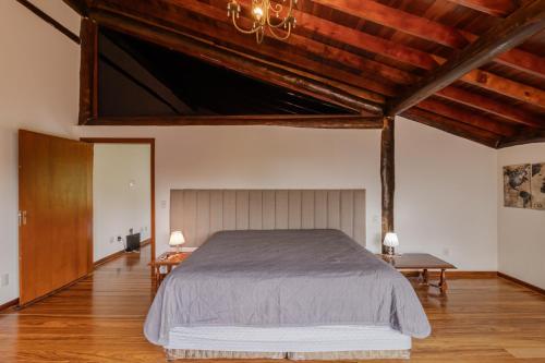 una camera con un grande letto e soffitti in legno di Casa de Campo Alto Padrao com Piscina e Jacuzzi a Pirituba