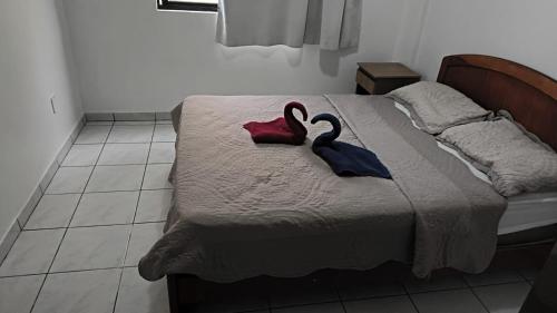 a bed with two swans towels sitting on it at Hotel Menegatti in Pato Branco