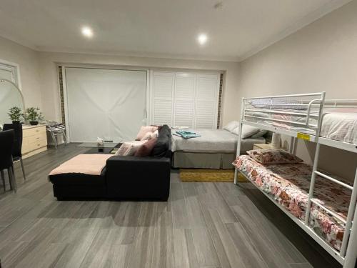 een persoon die op een bank ligt in een kamer met twee stapelbedden bij Serene Guest House in Callala Beach