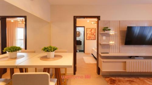 Una sala de estar con televisión, mesa y sillas. en Apartamento em Londrina no Centro da cidade, en Londrina