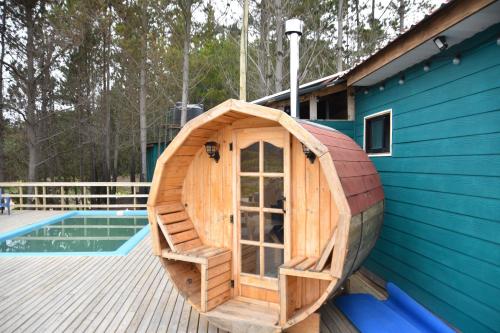 a small wooden boat on a deck next to a pool at Cabañas Isla del Mar in Constitución