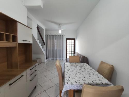 een keuken en eetkamer met een tafel en stoelen bij Casa em condomínio no centro de Bertioga in Bertioga