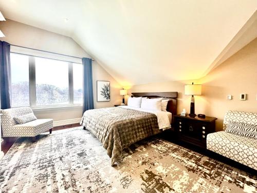 トロントにあるiResidence in Toronto - Unique Mansion - Fantastic Views with Breakfastのベッドと椅子のあるホテルの部屋