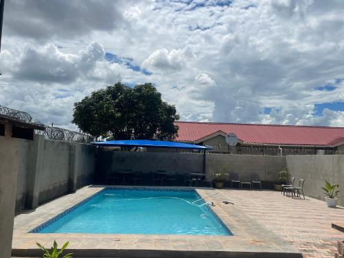een zwembad in een achtertuin met een hek bij Cadami apartments in Mazabuka