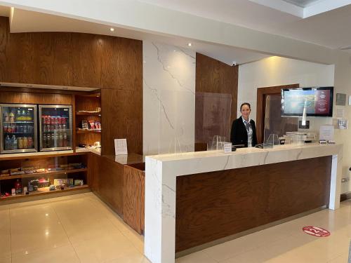 a man standing at a bar in a room at Best Western Plus Chihuahua Aeropuerto in Chihuahua